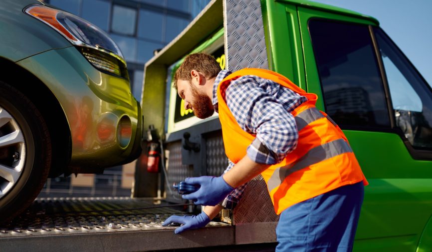Man working in towing service on road Handsome middle age man working in towing service on road. Roadside assistance and car evacuation