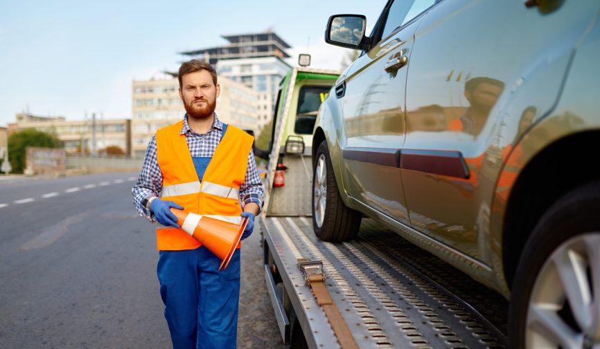 Road worker putting traffic cone on roadside Tow truck worker putting warning traffic cone on road. Roadside assistance and evacuation. Crop shot